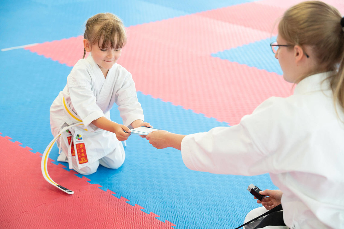 Ein kleiner Karate Tiger, ein Kleine Mädchen bei einer konzentrierten Übung auf der Matte  